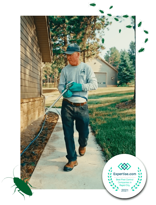 Warne Green Force employee spraying a home for pest control services
