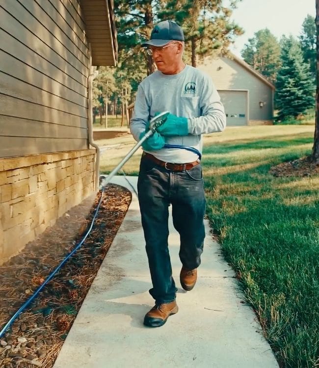 Warne worker spraying lawn for insect control